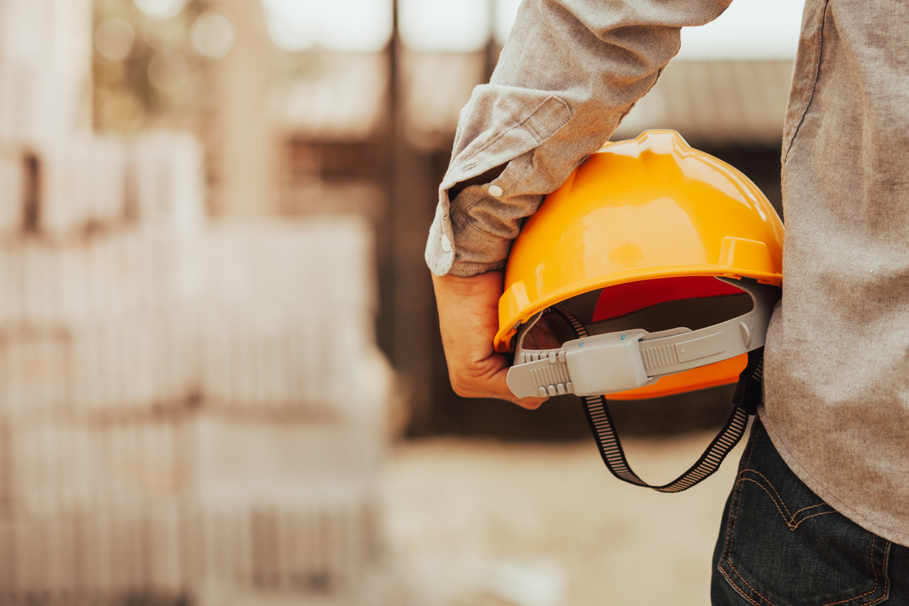 Mann hält Bauarbeiterhelm in den Händen